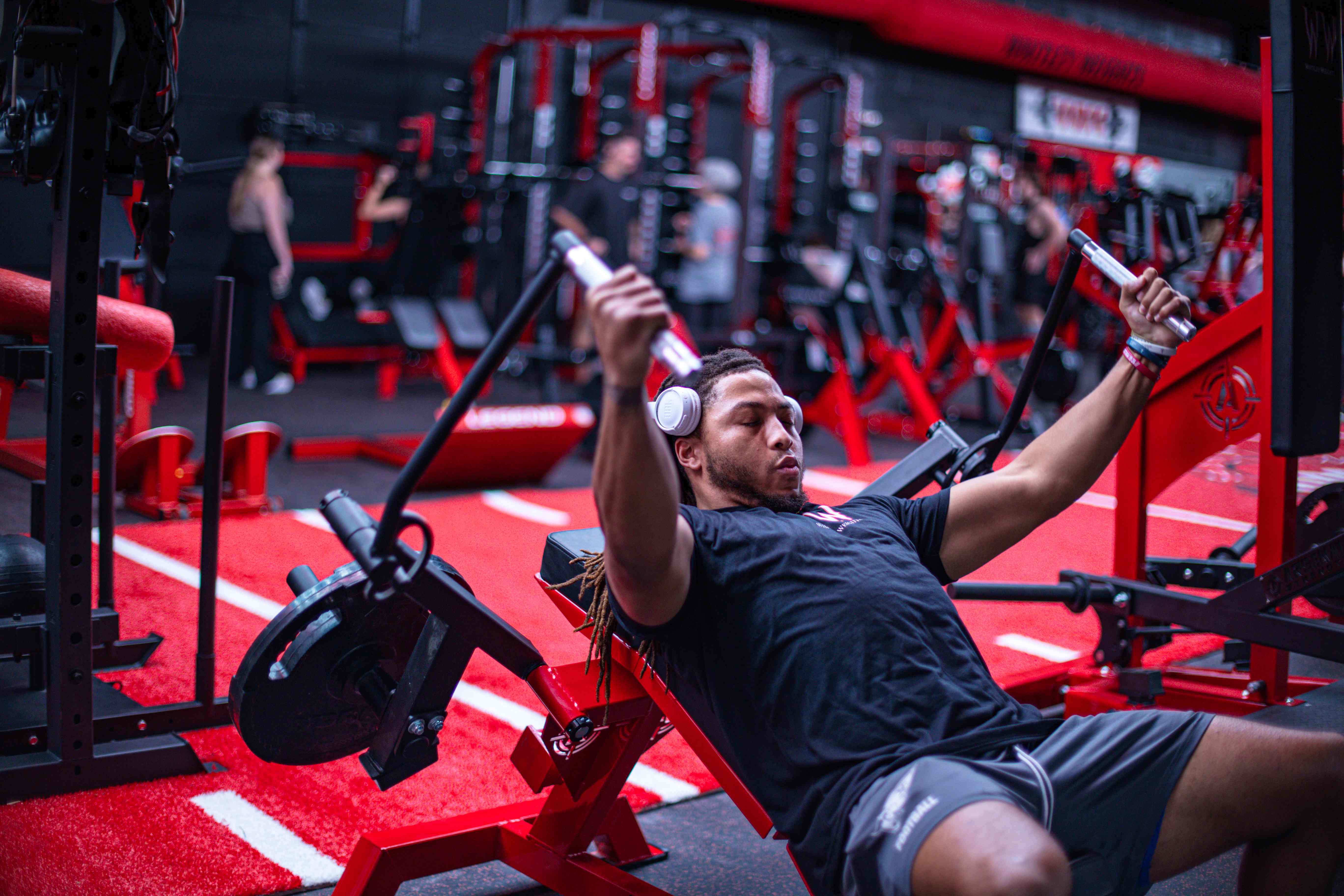 Athlete performing a seated chest fly on the red turf lane