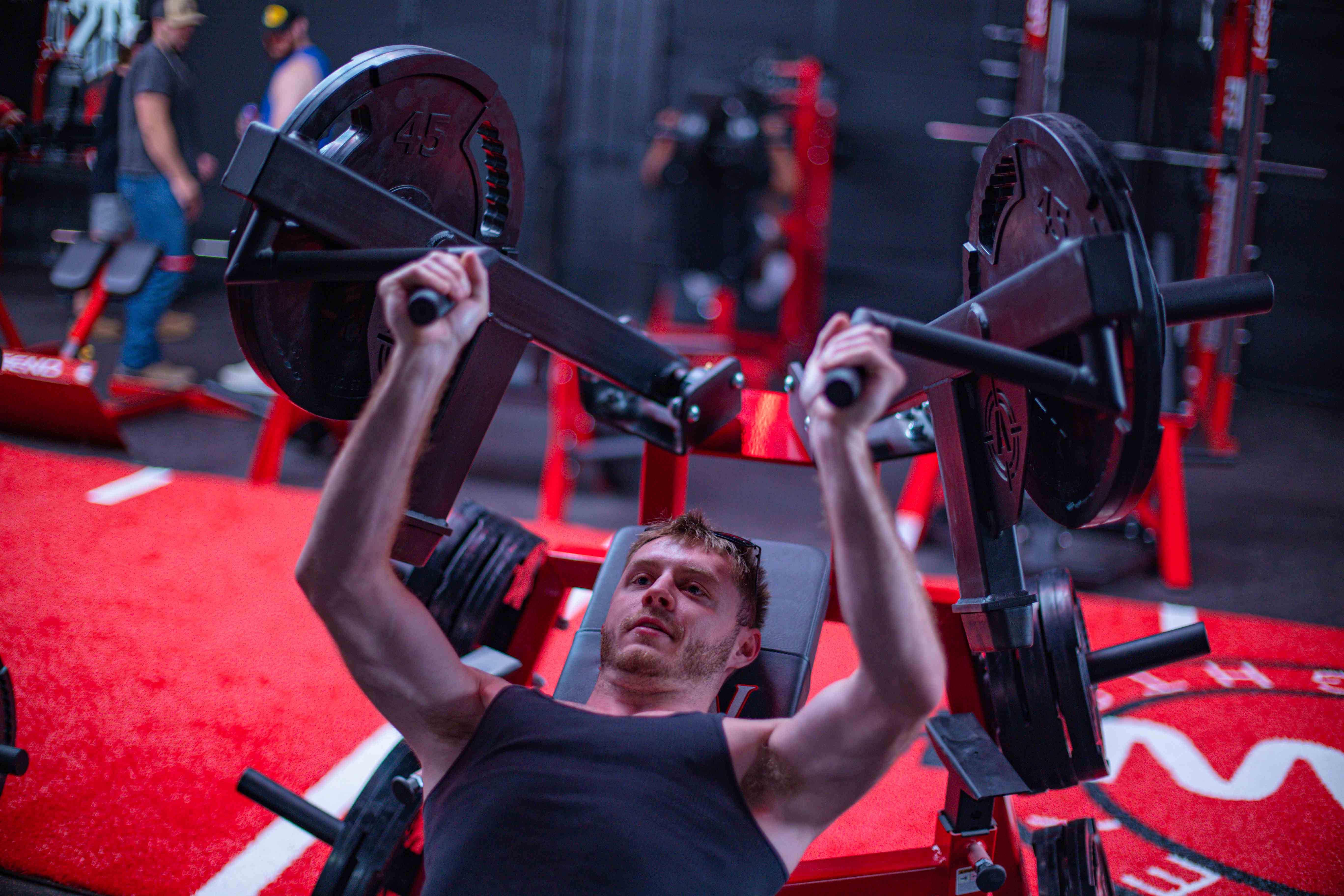 Member pressing on a plate-loaded chest press with 45s loaded