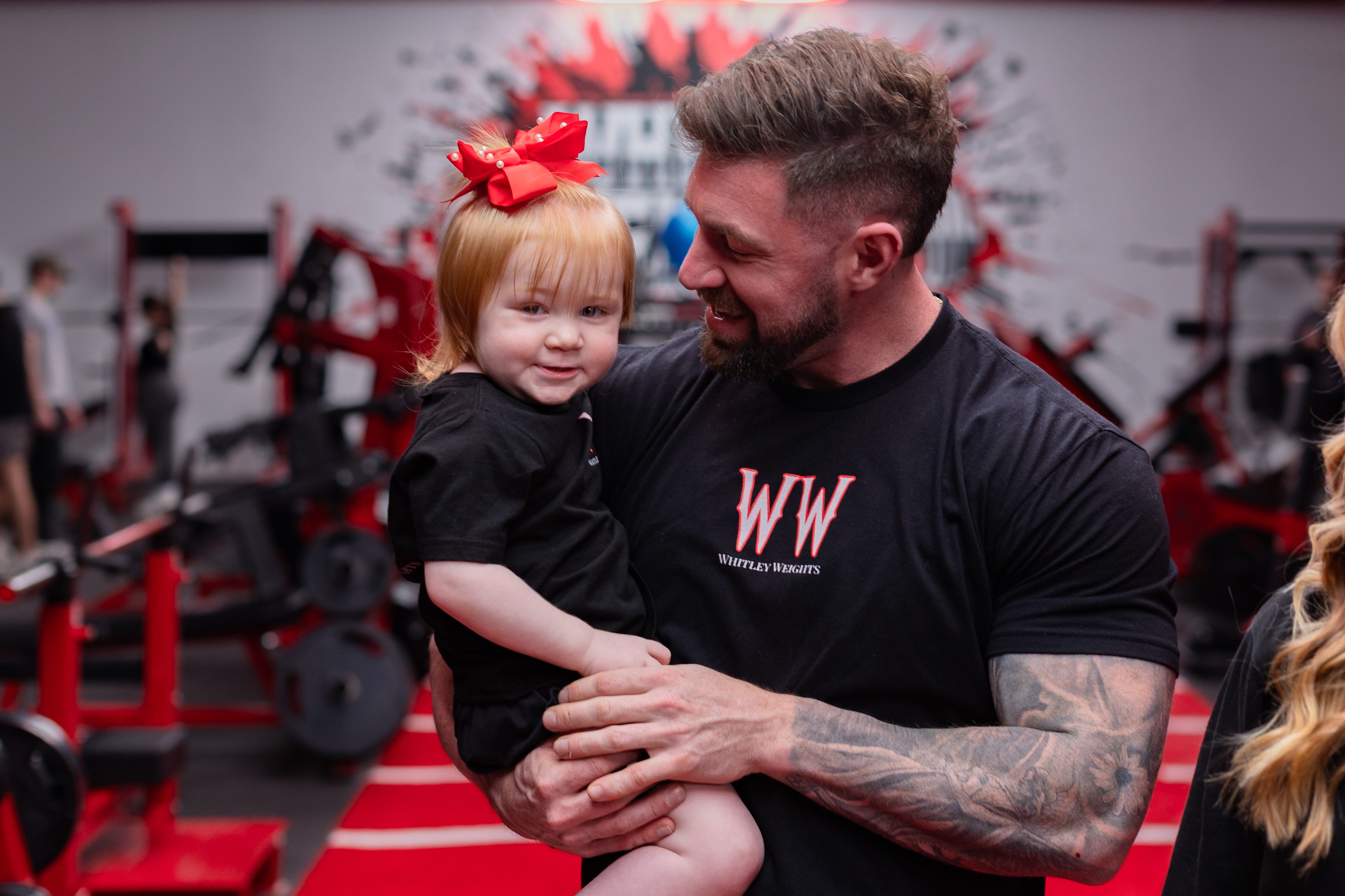 Owner holding his daughter in matching Whitley Weights shirts