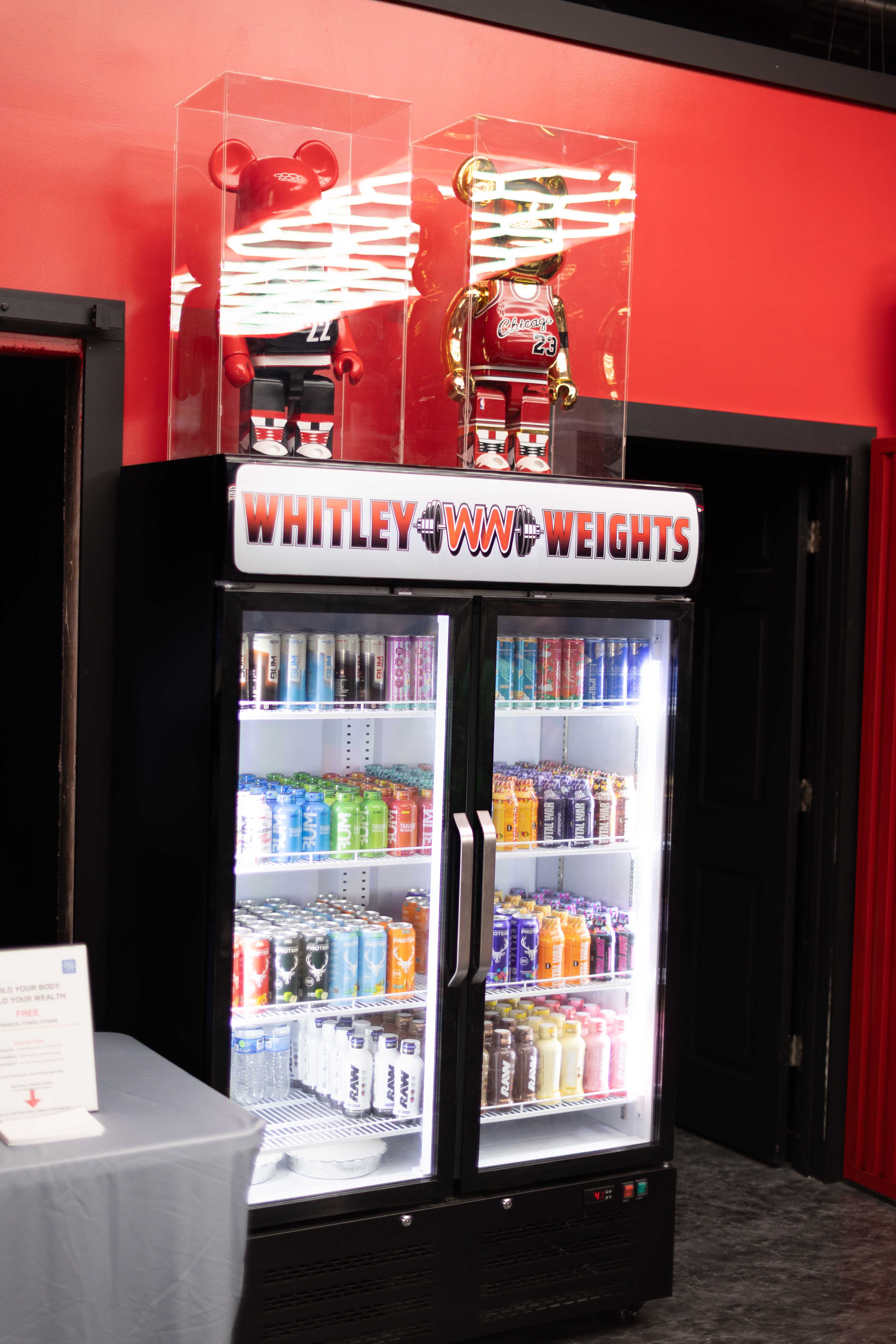 The branded Whitley Weights drink fridge topped with collectible figures