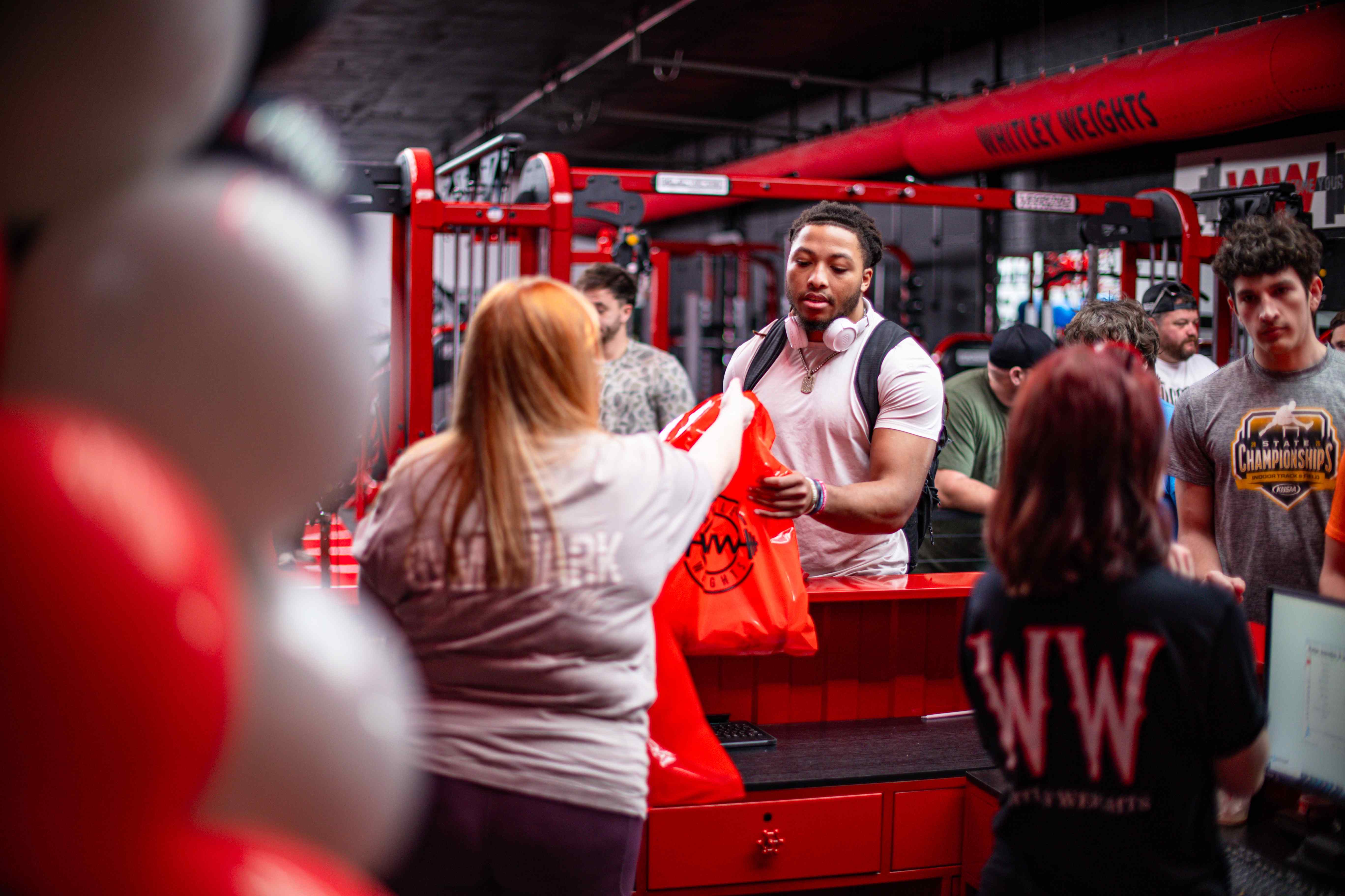 Member picking up a Whitley Weights swag bag at the counter