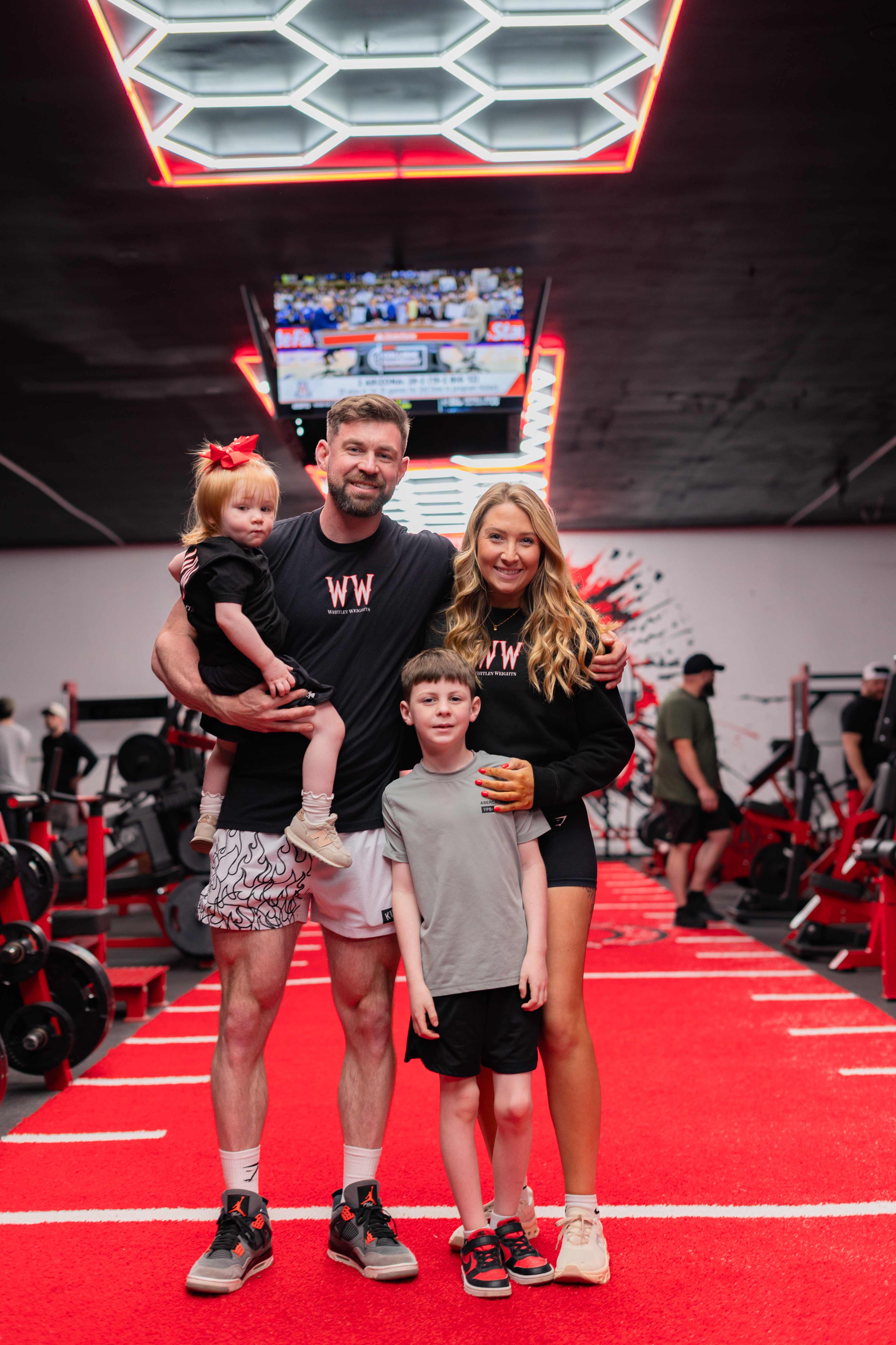 The Whitley Weights owner family on the red turf under the hex lights