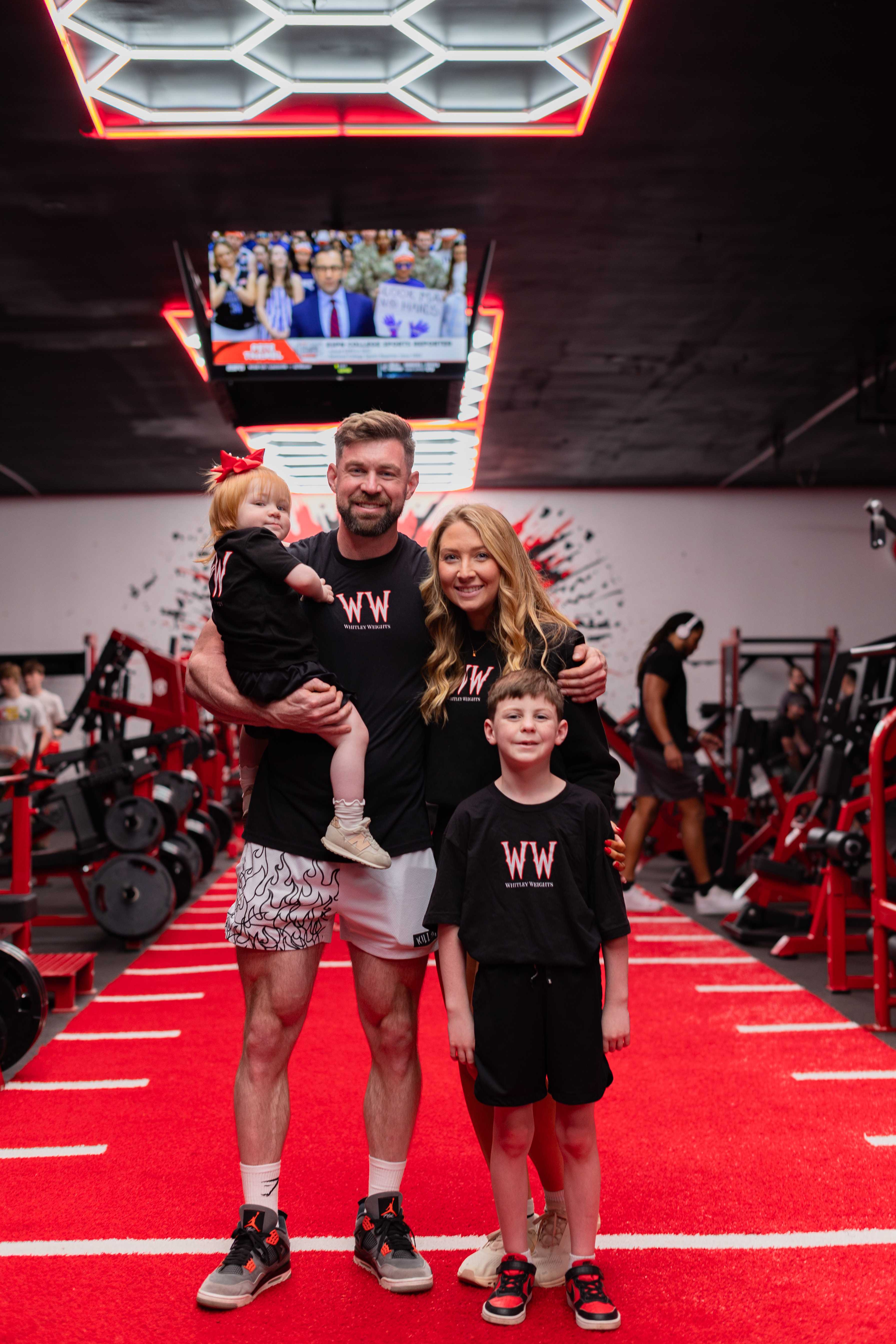 The owner family of four posing on the red turf runway