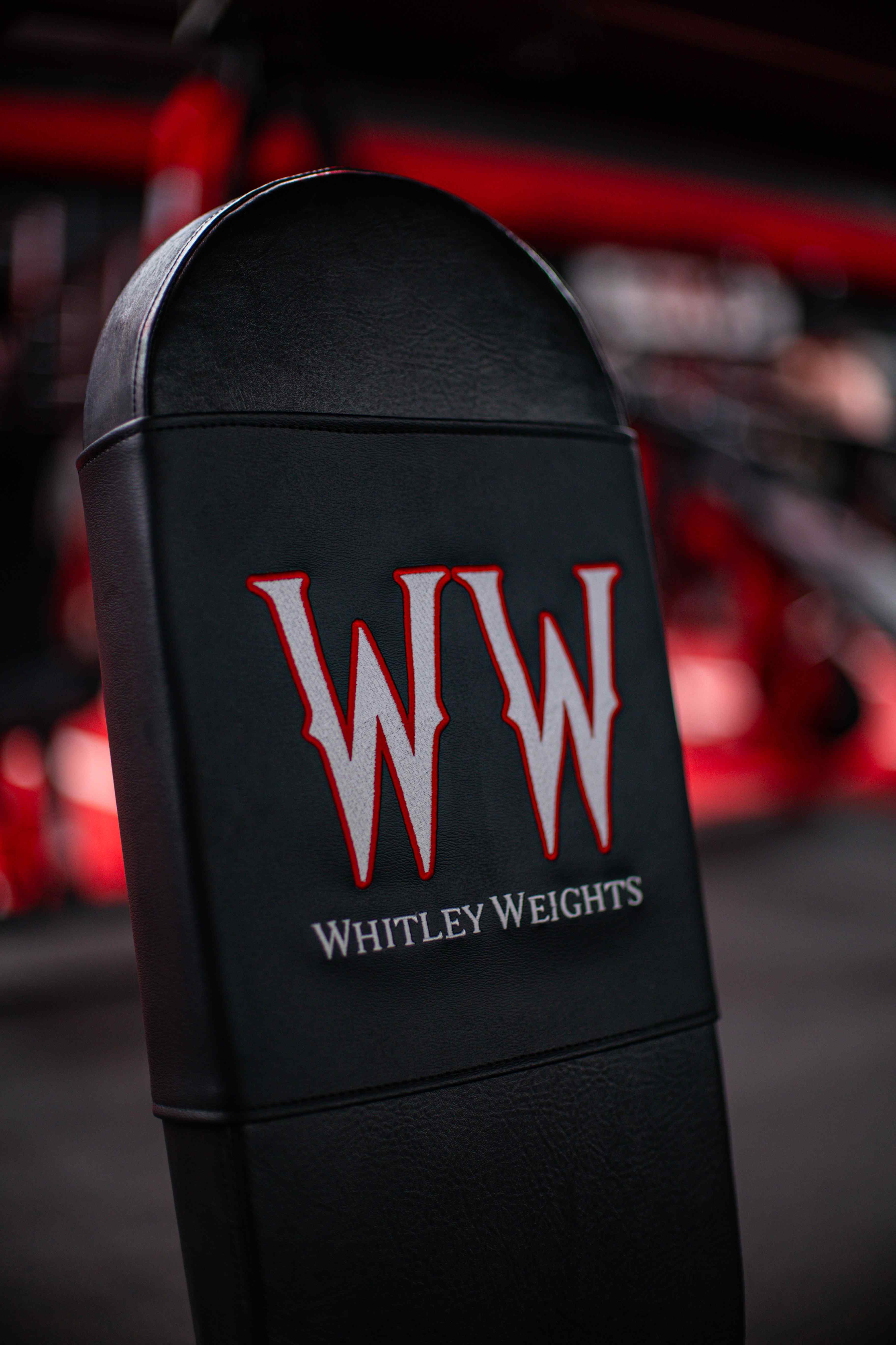 Whitley Weights branded pad against the red gym backdrop