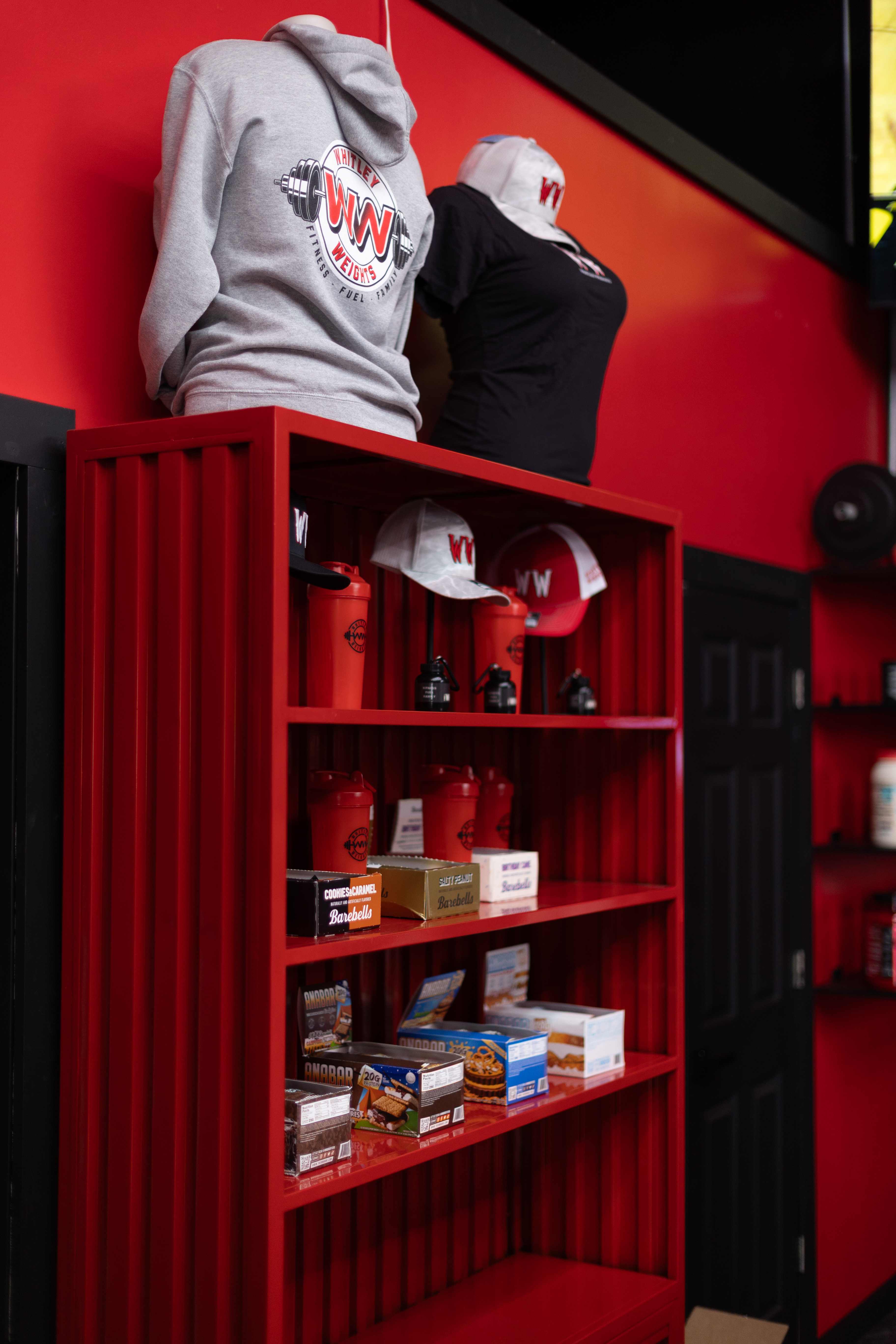 Whitley Weights pro shop shelf with apparel, hats, shakers and protein bars
