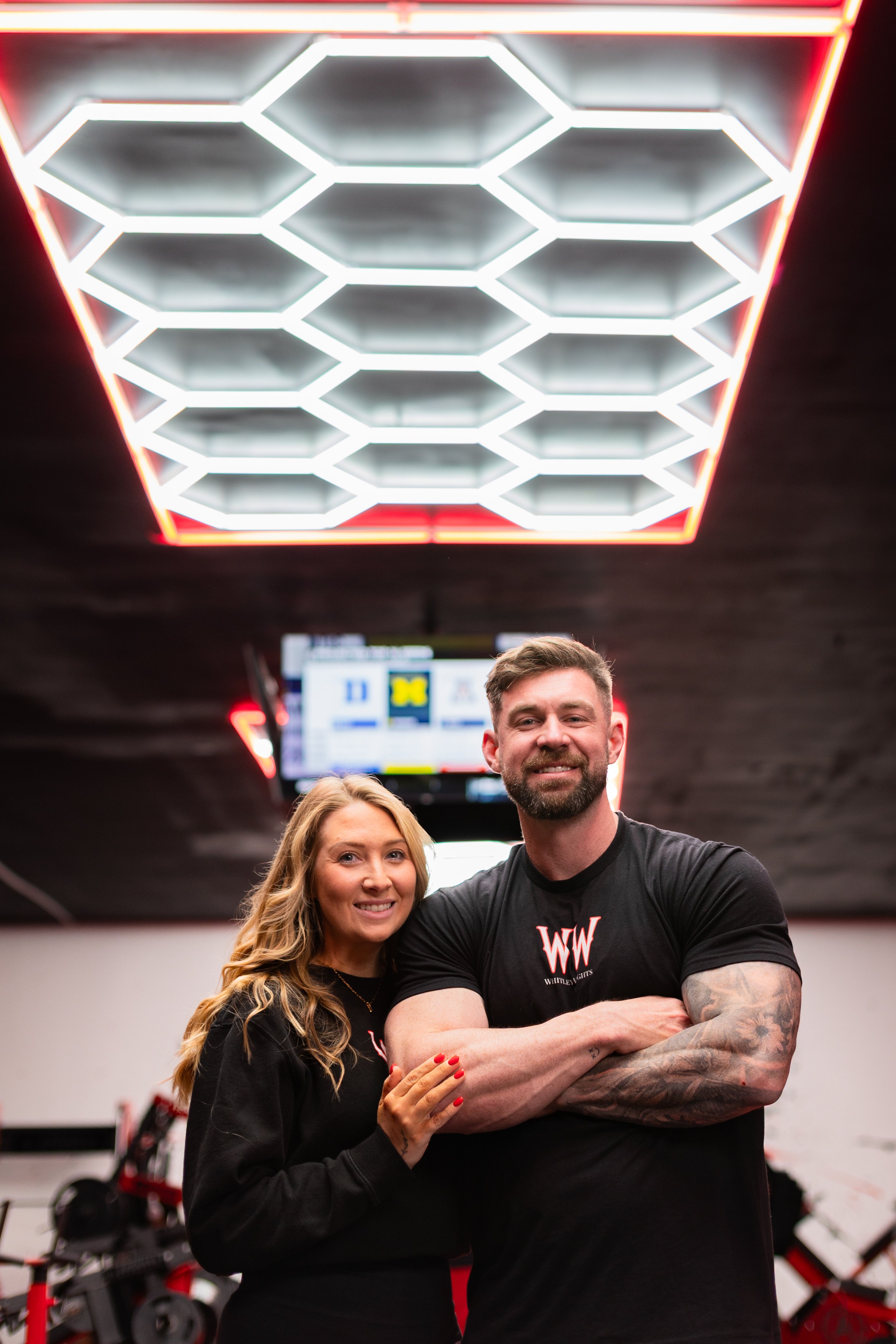 The Whitley Weights owners together beneath the hex ceiling lights