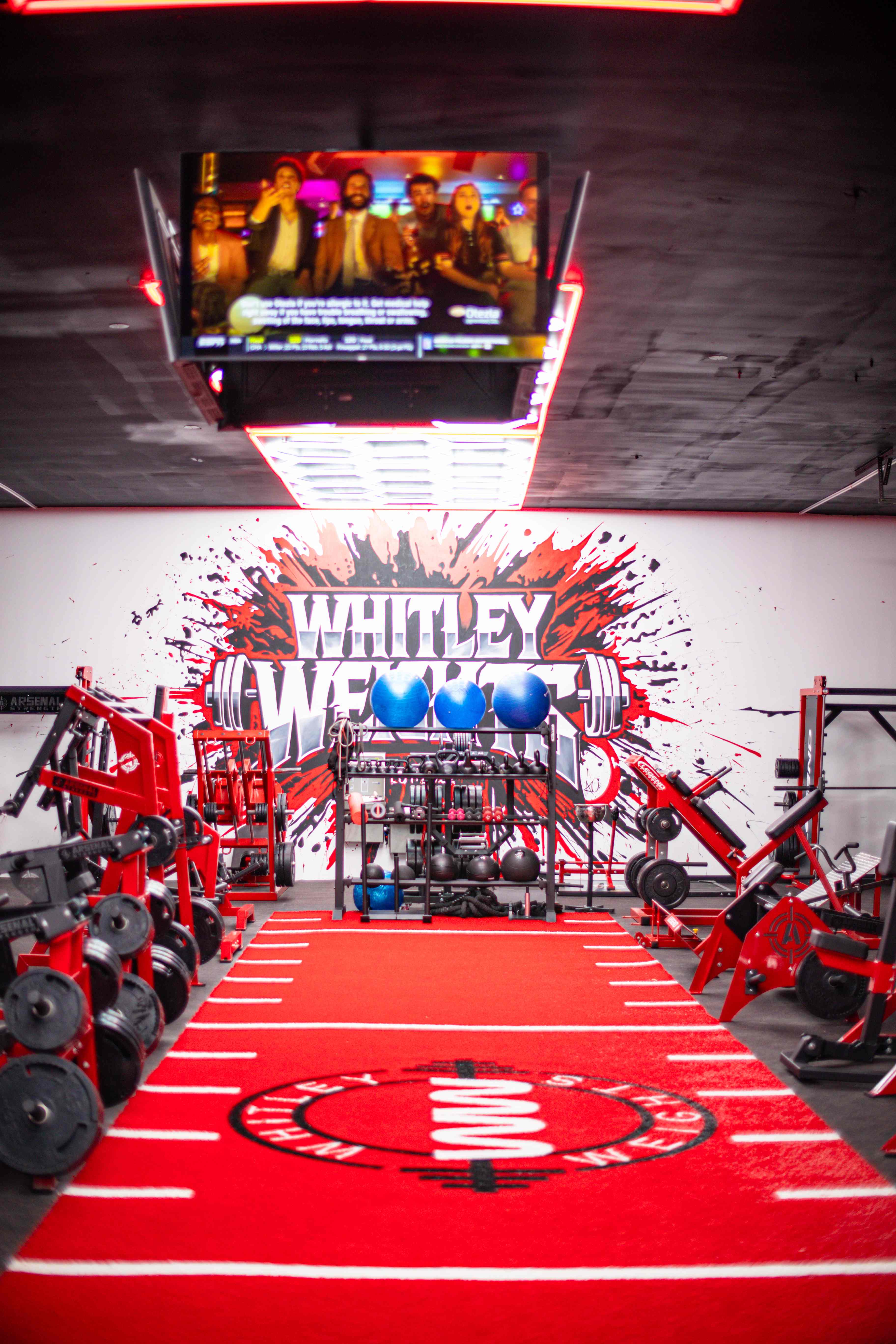 Training floor and turf runway beneath the Whitley Weights mural
