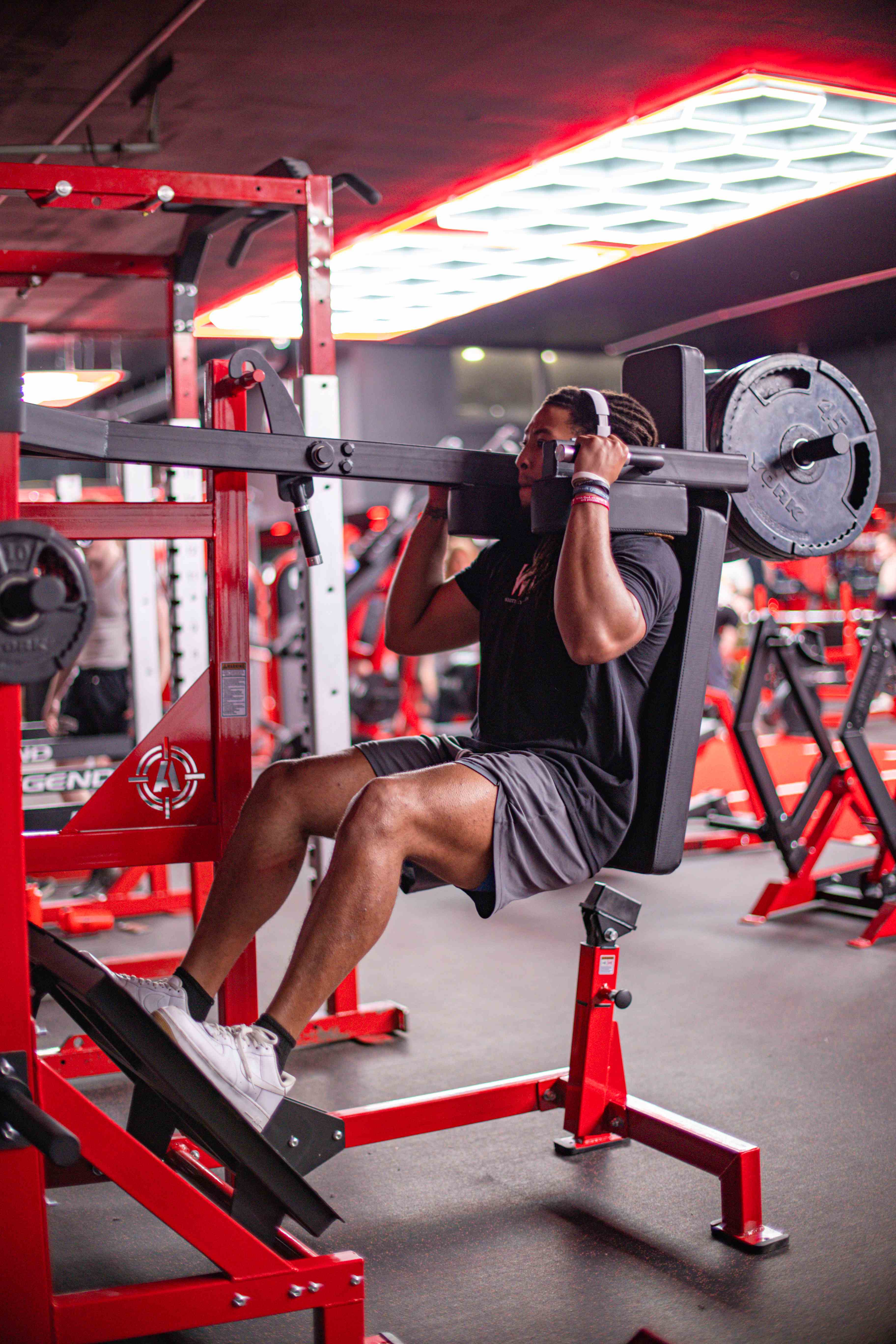 Athlete training on a plate-loaded shoulder press