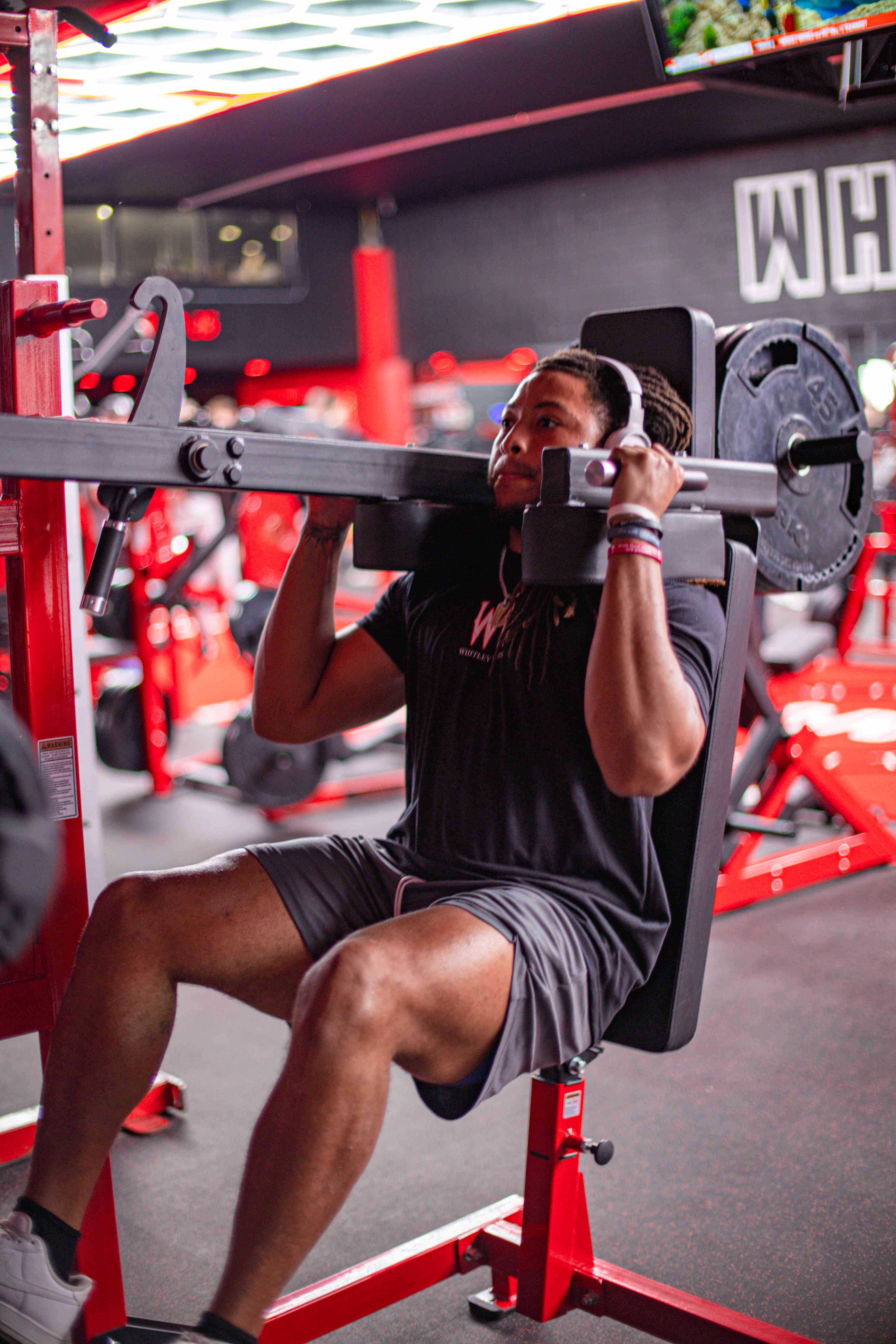Member pressing overhead on a plate-loaded machine