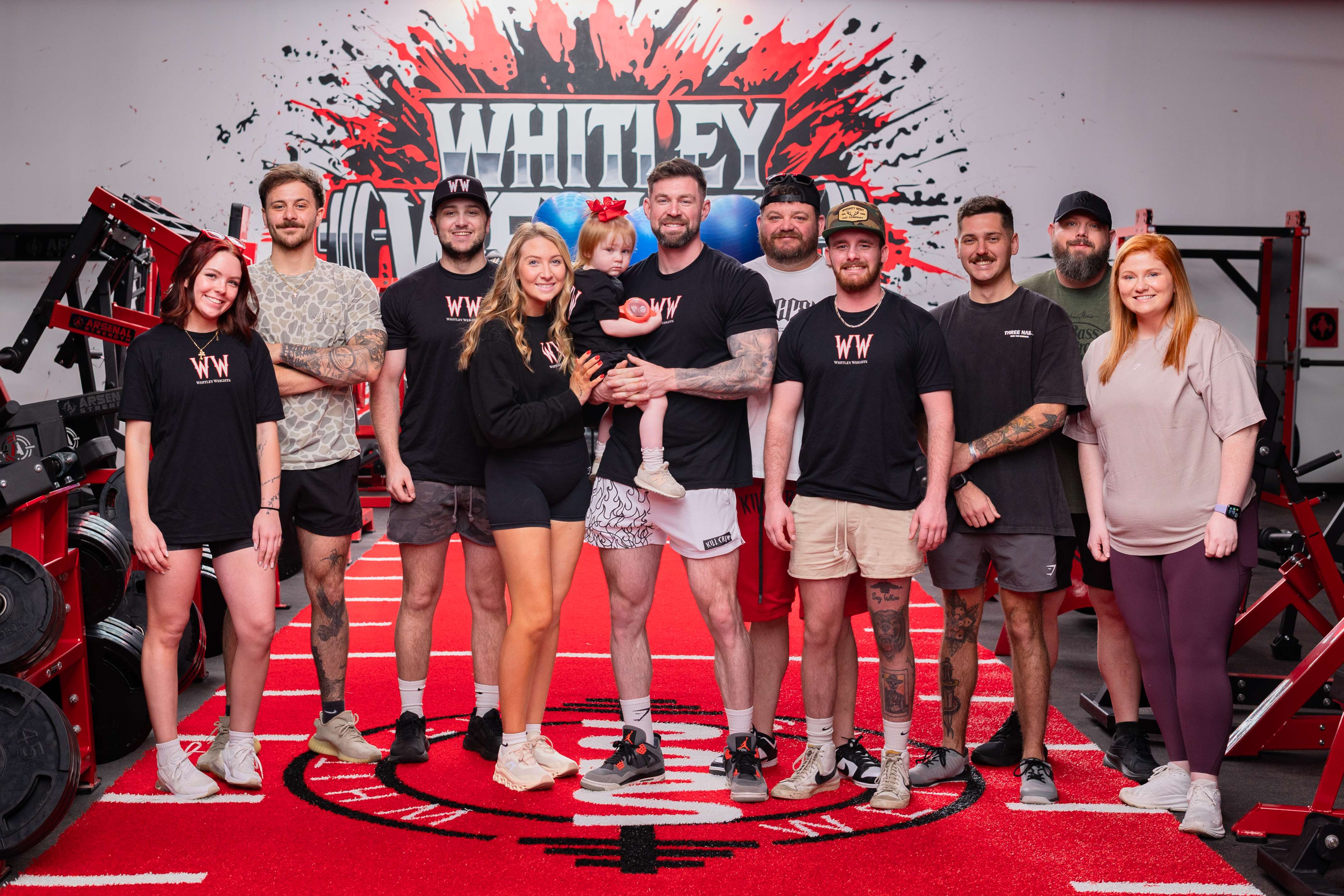 Whitley Weights staff and family gathered on the logo turf