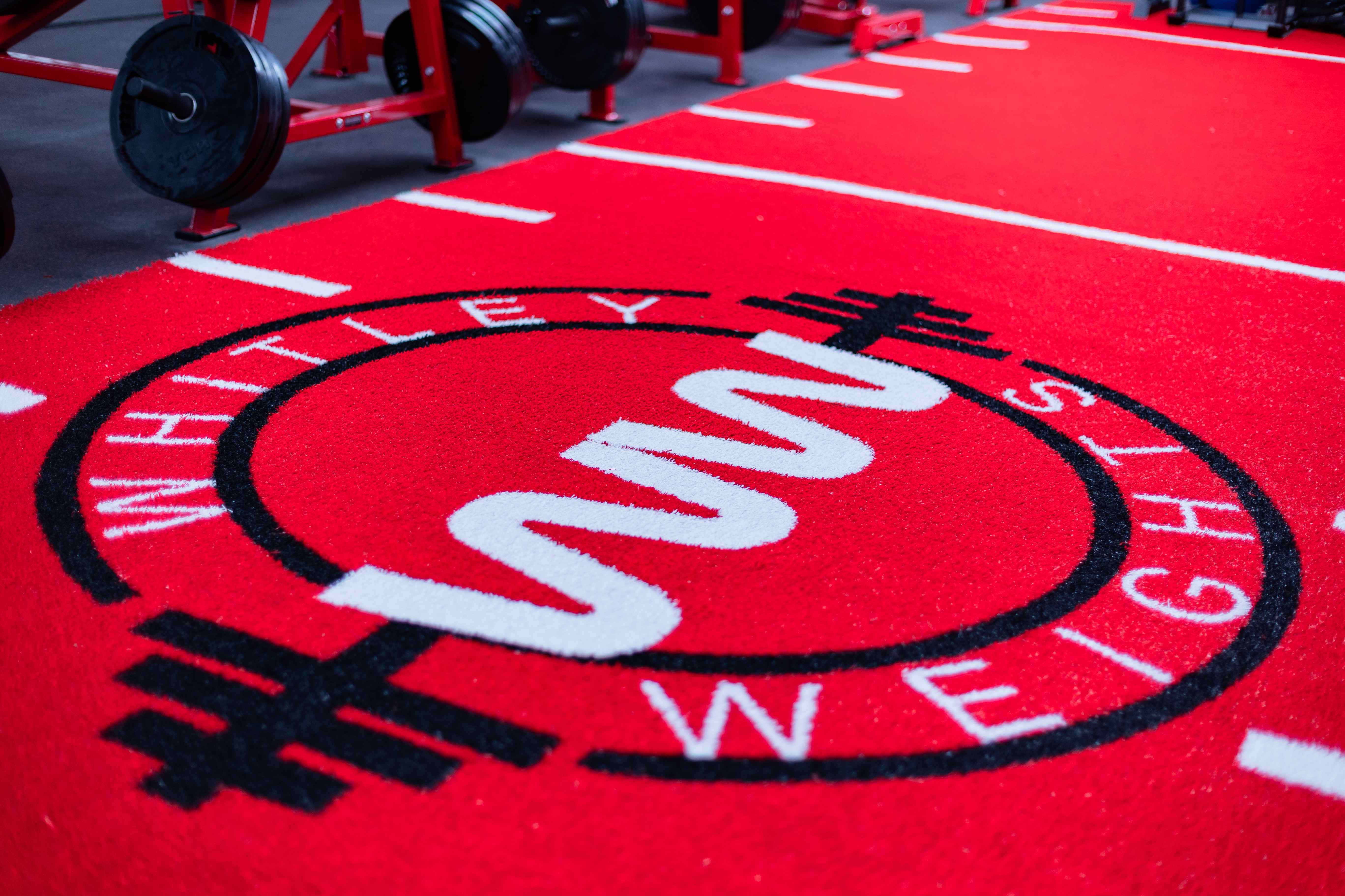 Angled view of the Whitley Weights logo turf and weights